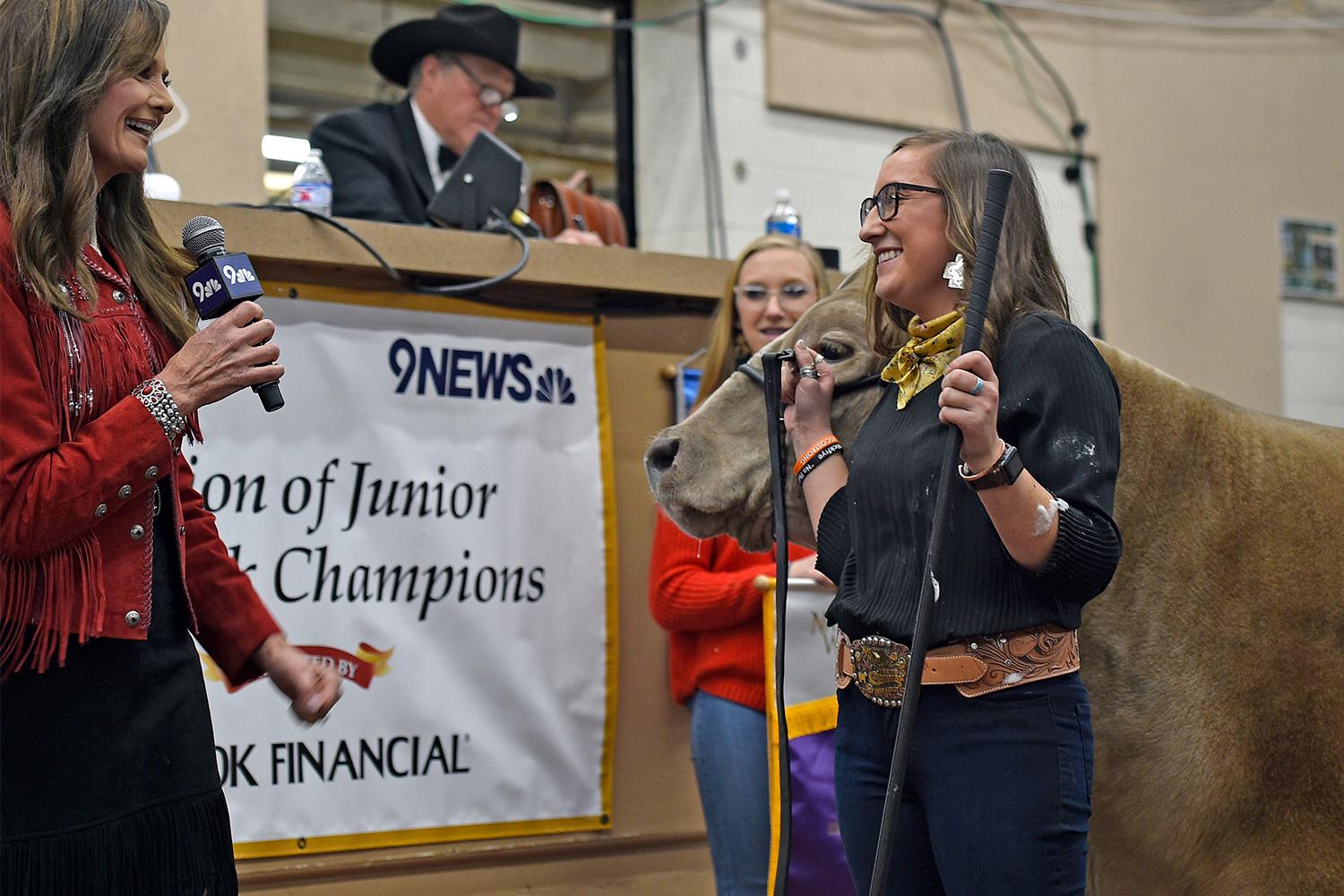 Auction of Junior Livestock Champions, female steer exhibitor is interview on the auction block by Kathy Sabine of 9News
