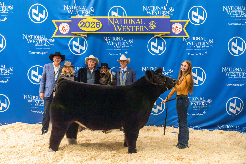 Cannon Reinmann, with her Grand Champion Steer, Boots, and buyers from Bank of Colorado